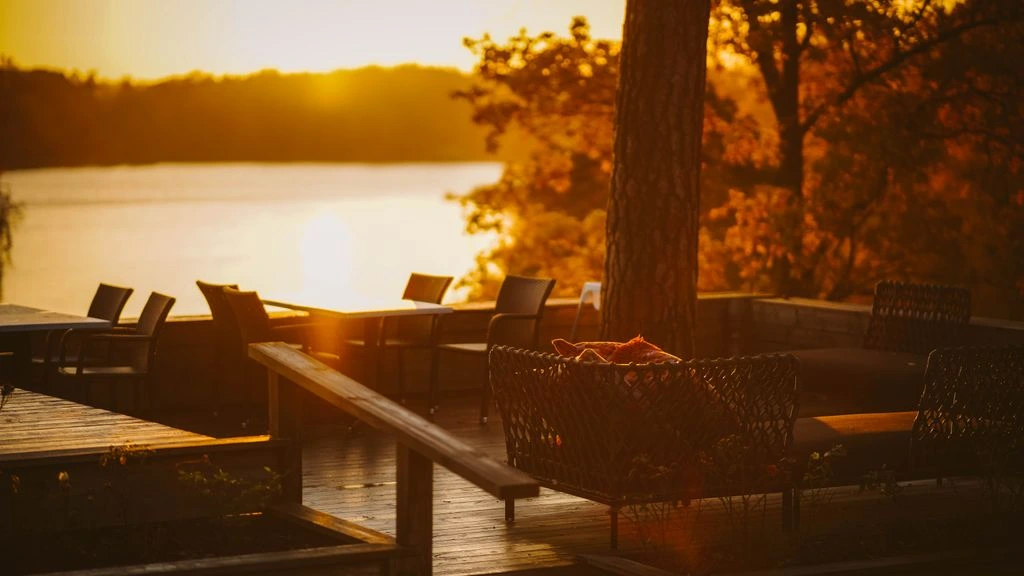 The Coppermine Pub's heated lakeside patio at golden hour, looking out over the water.